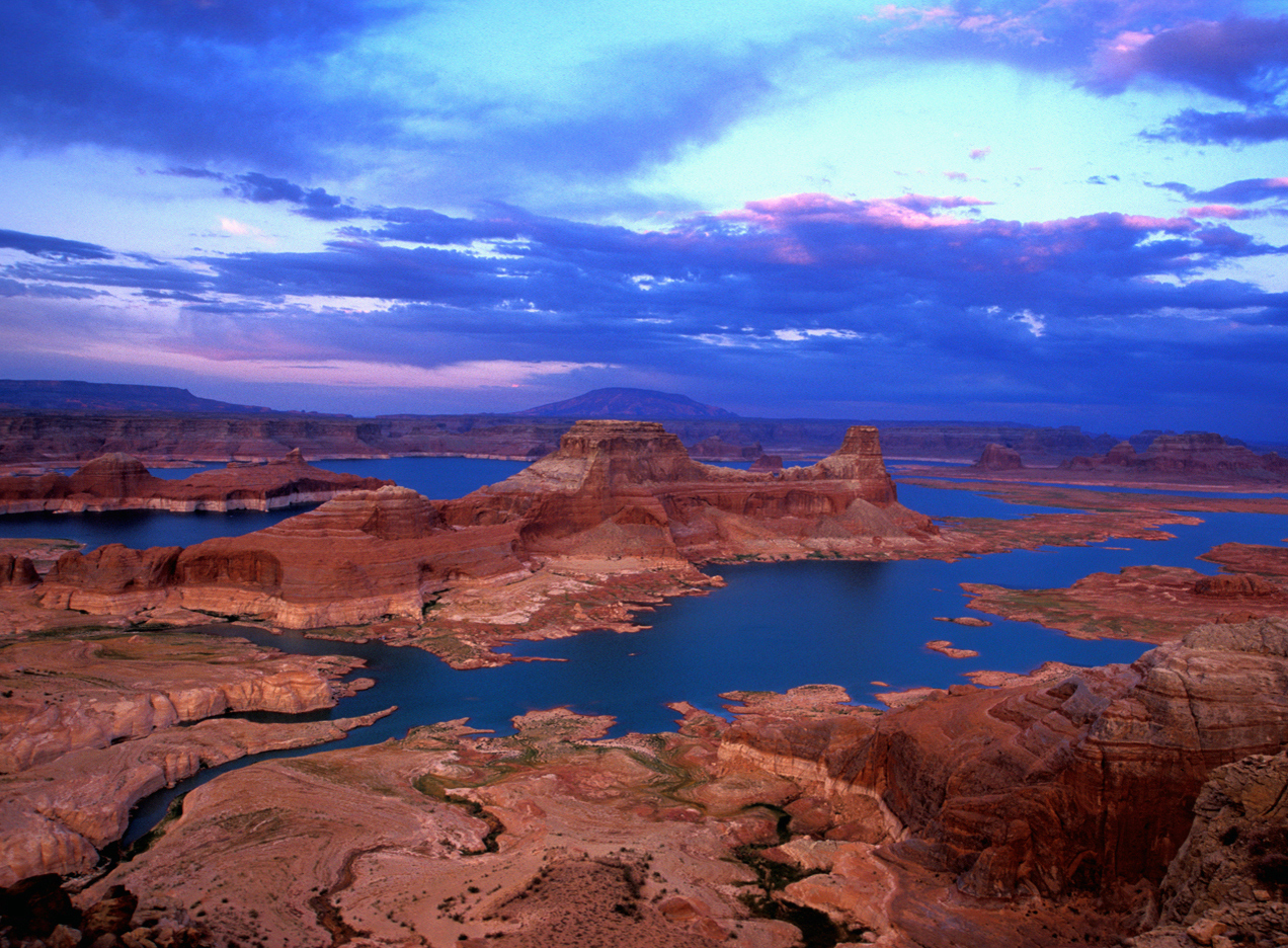 Lake Powell in the Glen Canyon Recreation Area is a large desert lake surrounded by magnificent red rock cliffs.